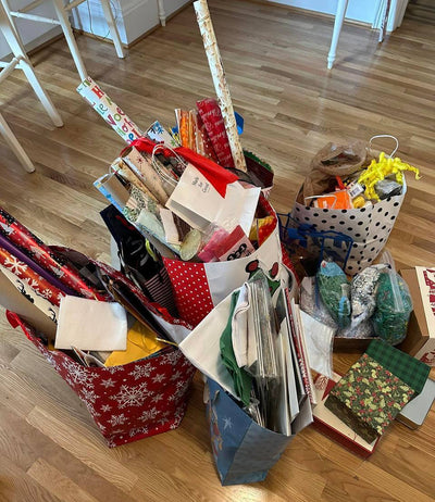 Boden voller Geschenkpapier, Tüten und Rollen am Abend vor Heiligabend